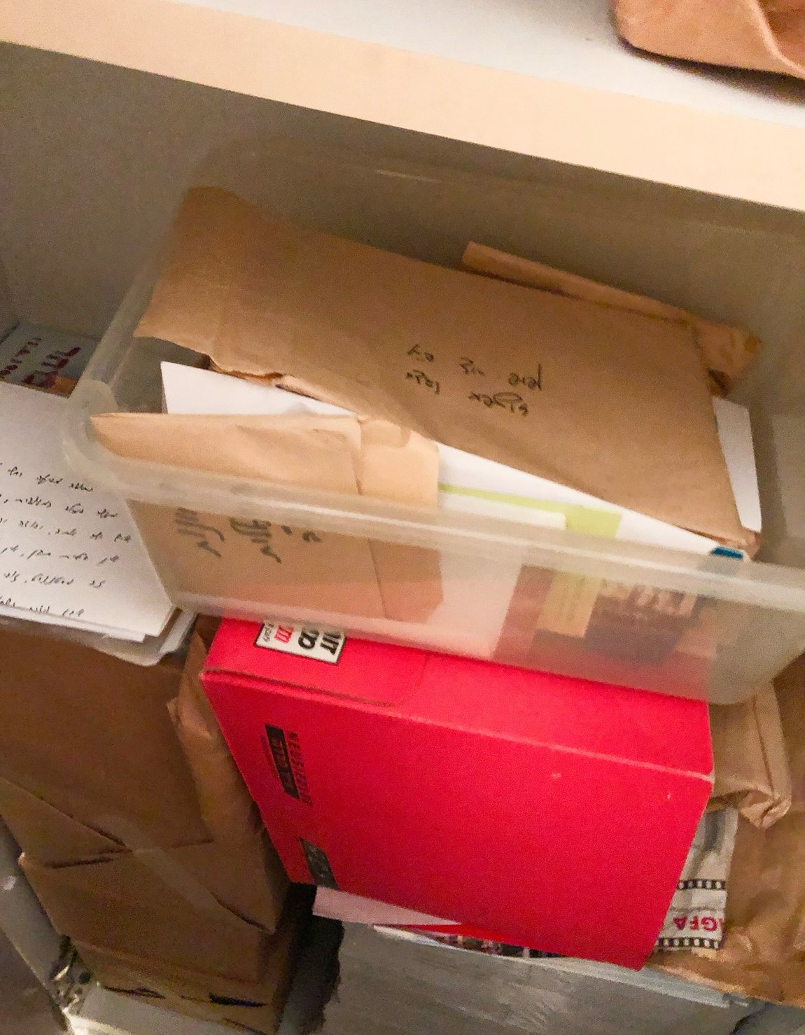Envelopes labelled by hand, stacked on a shelf