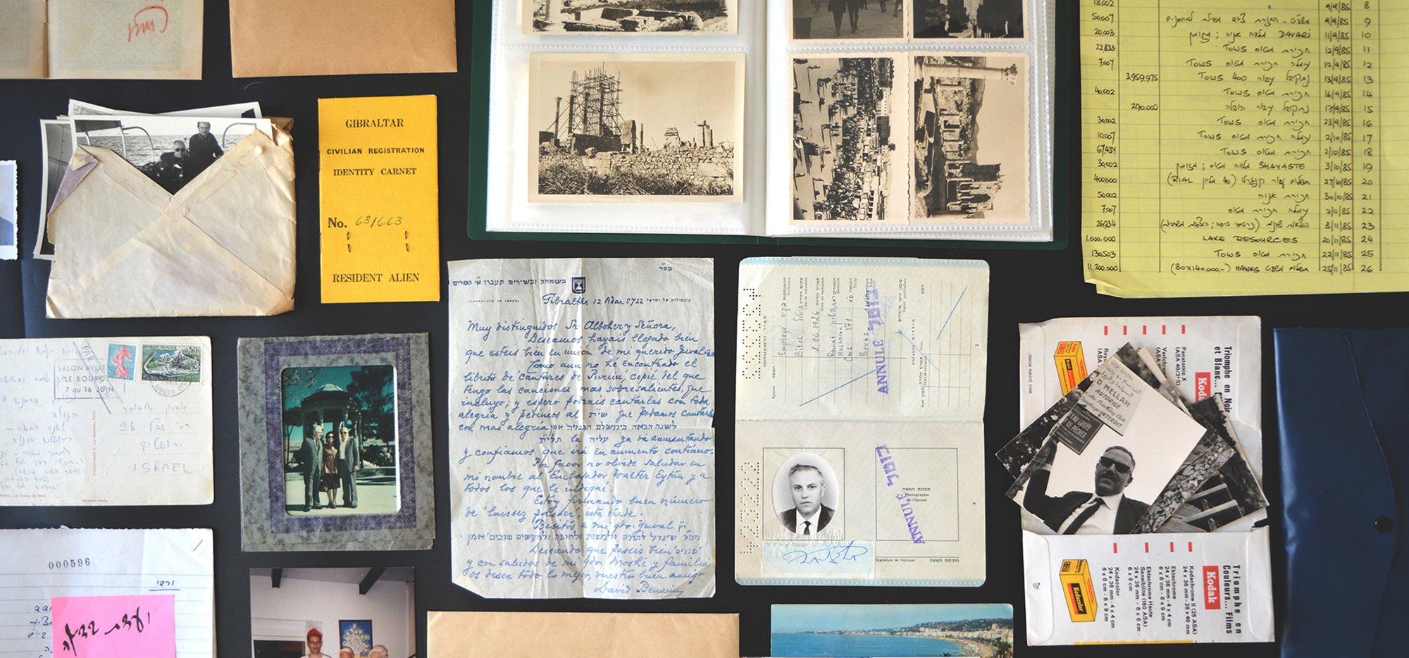 Passports, letters, photos and ledgers laid out on a table